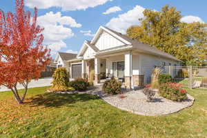 View of front of house with a standing seam roof, board and batten siding, covered porch, partial metal roof, and stone siding.