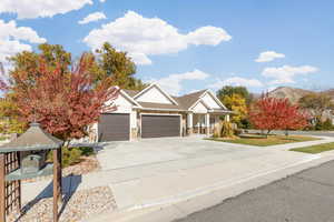 Craftsman inspired home with driveway, stone siding, two-car garage, a mountain view, and a porch.