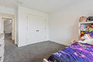 Carpeted bedroom featuring baseboards and a closet