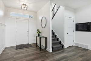 Foyer entrance featuring stairs and dark wood finished floors