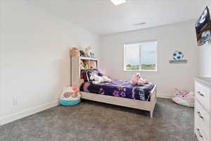 Bedroom featuring carpet flooring and baseboards