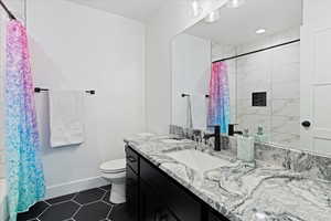 Bathroom featuring vanity and dark tile patterned floors