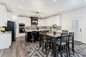 Dining room with light wood-style flooring and recessed lighting