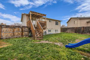 Back of property featuring stairs and a fenced backyard