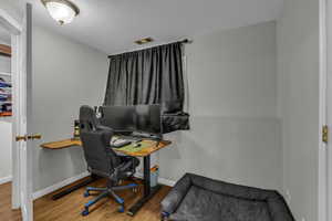 Office featuring wood finished floors and a textured ceiling