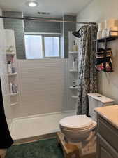 Full bath featuring a shower stall, vanity, and a textured wall