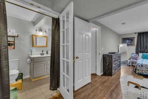 Bathroom featuring vanity, a shower with curtain, wood finished floors, and ensuite bath