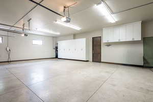 Garage with baseboards and a garage door opener