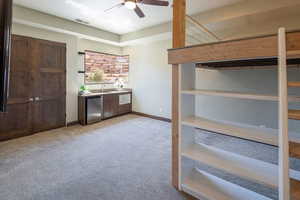 bedroom featuring light carpet and a ceiling fan