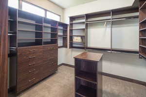 Walk in closet with light colored carpet