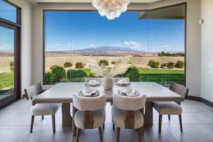 Dining room with tile patterned flooring, a chandelier, and a mountain view
