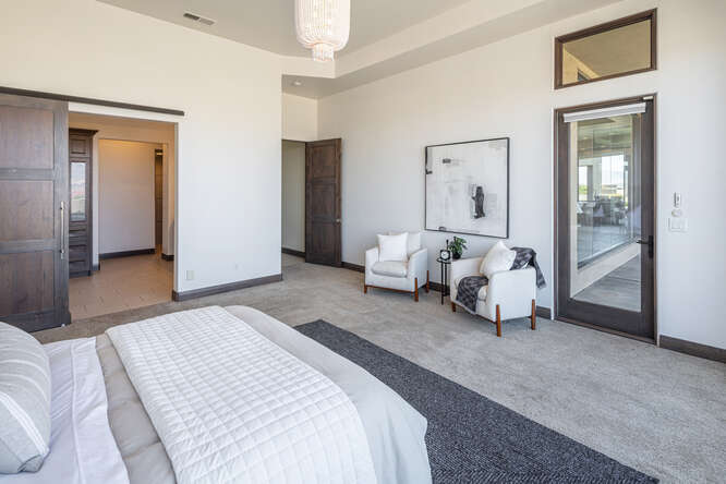 Carpeted bedroom with baseboards and access to exterior