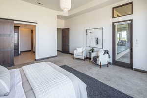 Carpeted bedroom with baseboards and access to exterior