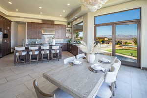 Dining area with a mountain view, recessed lighting, a raised ceiling, light tile patterned floors, and a chandelier
