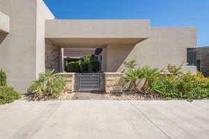 Property entrance featuring a gate and stucco siding