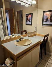 Bathroom with light tile patterned floors and vanity
