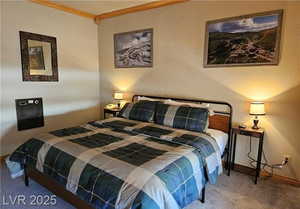 Carpeted bedroom with crown molding and a textured wall