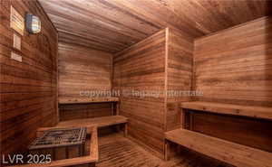 Relaxing sauna with wooden ceiling, hardwood / wood-style floors, and wood walls