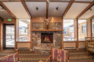 Sitting room featuring beam ceiling, a fireplace, healthy amount of natural light, baseboard heating, and a baseboard heating unit