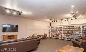 Living area with rail lighting, carpet floors, and a textured ceiling