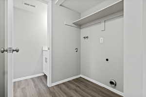 Laundry area with wood finished floors, hookup for an electric dryer, and washer hookup