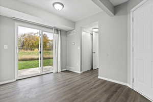 Unfurnished bedroom with dark wood-style flooring and access to exterior