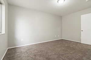 Spare room featuring carpet and a textured ceiling