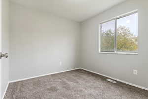 Carpeted spare room with baseboards