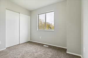 Unfurnished bedroom with carpet and a closet