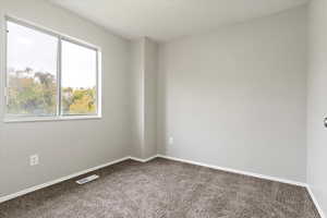 Unfurnished room featuring carpet floors and baseboards