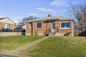 Bungalow-style home featuring brick siding and a chimney