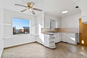 Kitchen with white cabinetry, light countertops, dishwasher, and healthy amount of natural light