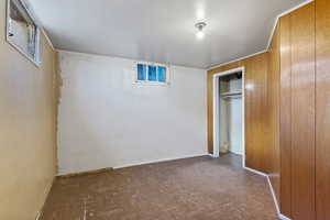 Unfurnished bedroom featuring a closet and wood walls