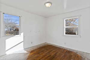 Unfurnished room with wood-type flooring and healthy amount of natural light