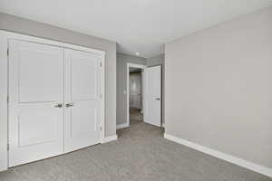 Unfurnished bedroom featuring carpet flooring and a closet