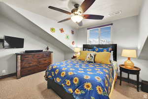 Bedroom featuring light colored carpet, a textured ceiling, and ceiling fan