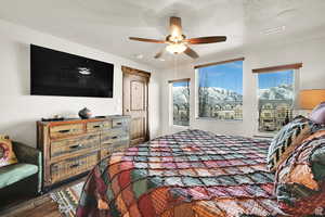 Bedroom featuring wood finished floors, a textured ceiling, and ceiling fan