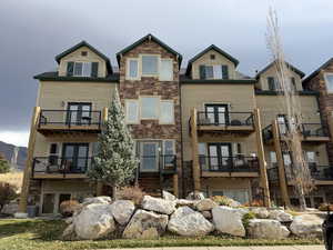Rear view of property featuring stone siding and french doors