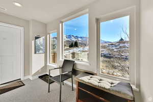 Sitting room featuring a mountain view, light colored carpet, and recessed lighting