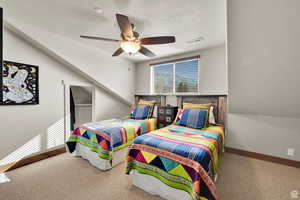 Carpeted bedroom featuring a ceiling fan and a textured ceiling