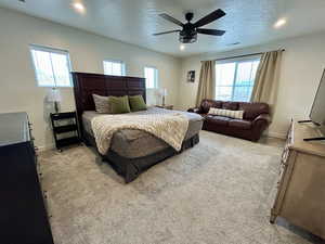 Bedroom with light colored carpet, a textured ceiling, a ceiling fan, and recessed lighting