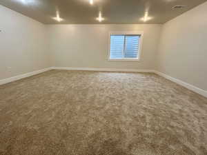 Unfurnished room featuring light colored carpet and a textured ceiling