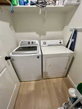 Washroom featuring light wood finished floors and washing machine and clothes dryer