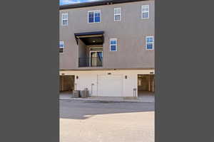 Back of house featuring a balcony, stucco siding, and a garage