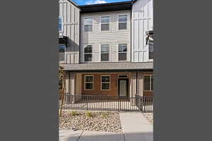 View of front of property with board and batten siding, brick siding, and a porch