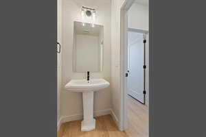 Half bathroom featuring light wood-style floors and baseboards