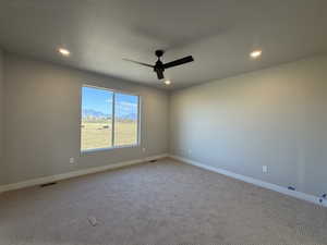 Carpeted spare room featuring a mountain view, ceiling fan, and recessed lighting