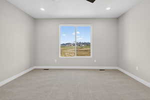 Empty room featuring carpet floors, a ceiling fan, and recessed lighting