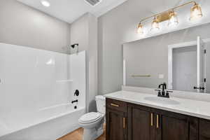 Full bath with shower / bath combination, vanity, and light wood finished floors