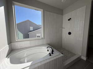 Bathroom featuring a garden tub, a tile shower, and tile patterned flooring